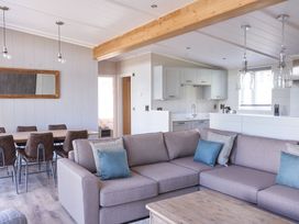 A living room with a sofa and dining area at Milk Wood 3 in Laugharne