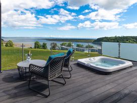 An outdoor area with a hot tub and chairs at Apex Spa in Laugharne