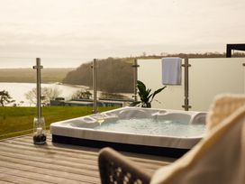An outdoor area with a hot tub on decking at Apex Spa in Laugharne