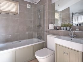 A bathroom featuring a bath tub, sink and shower at Apex Spa in Laugharne
