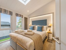 A bedroom with a bed and windows at Apex Spa in Laugharne