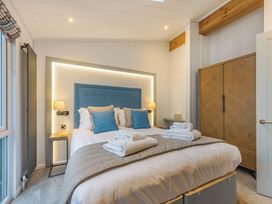 A bedroom with a bed and wardrobe at Apex Spa in Laugharne