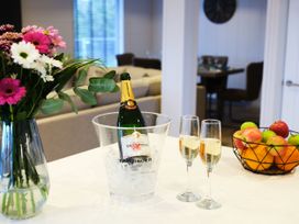 A kitchen with a champagne bottle in an ice bucket and fruit on the counter at Epic Spa in Laugharne