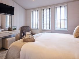 A bedroom with a bed and a chair at Epic Spa (Pet) in Laugharne
