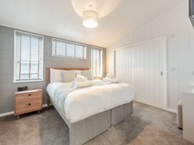A bedroom with a bed and bedside table at Sonnet 3 Spa (Pet) (Roof Terrace) Laugharne