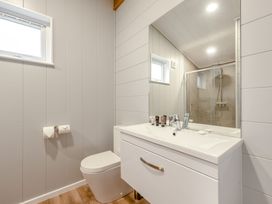 A bathroom with sink, toilet, mirror, and shower at Sonnet 3 Roof Terrace Spa in Laugharne