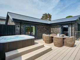 An outdoor area with a jacuzzi and seating furniture at Glan Y Mor in Laugharne