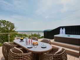 An outdoor terrace with a table and chairs at Glan Y Mor in Laugharne