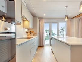 A kitchen with a sliding door and island at Epic Spa (Roof Terrace) in Laugharne