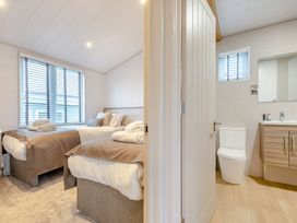 A bedroom with two beds and an adjoining bathroom at Epic Spa (Roof Terrace) in Laugharne