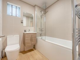 A bathroom with a toilet, sink, mirror, shower, and bathtub at Epic Spa (Roof Terrace) in Laugharne