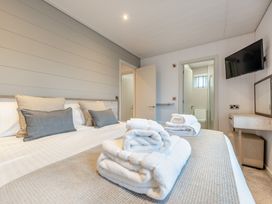 A bedroom with a bed and towels at Epic Spa (Roof Terrace) Laugharne