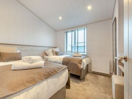 A bedroom with two beds and a window at Epic Spa (Roof Terrace) (Pet) in Laugharne