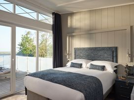 A bedroom with a bed and large windows at Canto Spa (pet) Laugharne