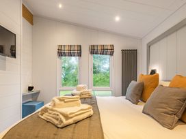 A bedroom with a bed and cushions at Apex Spa (Pet) in Laugharne