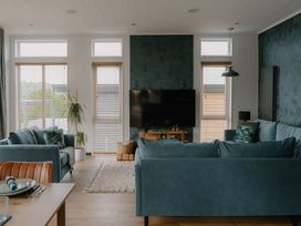 A living room with a sofa and television at Wilde in Laugharne