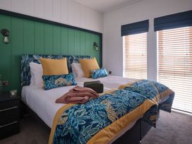 A bedroom with two beds and decorative pillows at Wilde in Laugharne