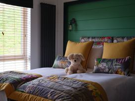 A bedroom with a bed and decorative pillows at Wilde in Laugharne