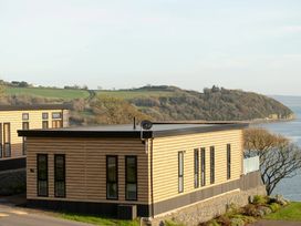 A building with windows and a door overlooking a landscape at Solace in Laugharne