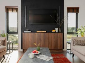 A living room with a television and cabinets at Solace in Laugharne