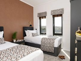 A bedroom with two beds and a small table at Solace in Laugharne