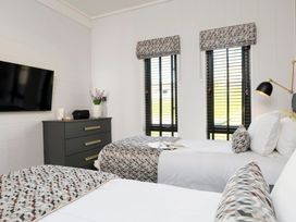 A bedroom with two beds and a television at Solace in Laugharne