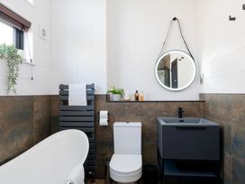 A bathroom with a bathtub, toilet, and sink at Solace in Laugharne