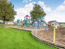 A playground with swings and a climbing frame at Solace in Laugharne