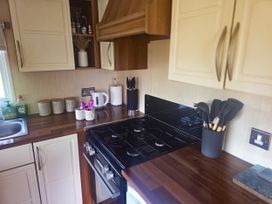 A kitchen with cabinets and stove at Caravan 1 at Blackmoor Farm near Tenby