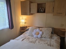 A bedroom with a double bed and lamp at Caravan 1 at Blackmoor Farm near Tenby Narberth
