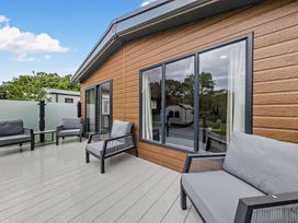 A deck with outdoor furniture and windows at Saron 2.0 Pet in Llandyrnog