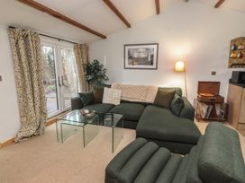 A living room with a green sofa and glass coffee table at 20 Chatham Log Cabins in Caernarfon