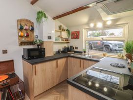 A kitchen with cabinets and appliances at 20 Chatham Log Cabins in Caernarfon