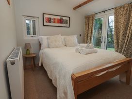 A bedroom with a bed and towels arranged at 20 Chatham Log Cabins in Caernarfon