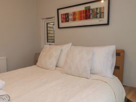 A bedroom with a bed and wall art at 20 Chatham Log Cabins in Caernarfon