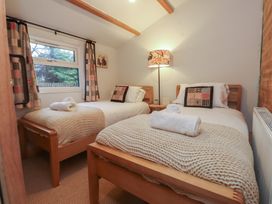 A bedroom with two beds and a lamp at 20 Chatham Log Cabins in Caernarfon