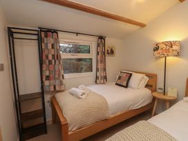 A bedroom with two beds and a lamp at 20 Chatham Log Cabins, Caernarfon