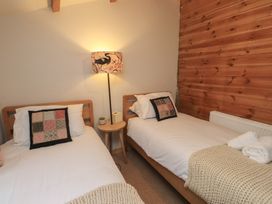 A bedroom with two single beds and a lamp at 20 Chatham Log Cabins in Caernarfon