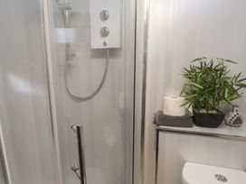 A bathroom with a shower and toilet at 20 Chatham Log Cabins Caernarfon