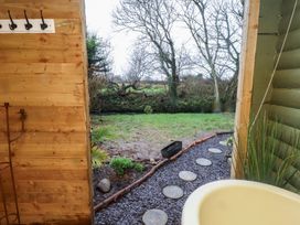 An outdoor area with a tub and a garden view at 20 Chatham Log Cabins in Caernarfon