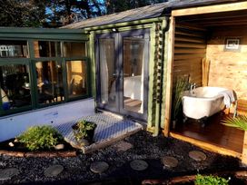 A garden with a doorway and a bathtub at 20 Chatham Log Cabins in Caernarfon