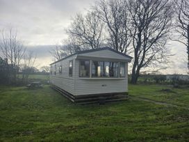 A caravan surrounded by trees and grass at Caravan 5 at Blackmoor Farm near Tenby