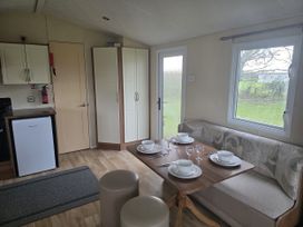 A dining area with a table set for meals at Caravan 5 at Blackmoor Farm near Tenby