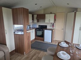 A kitchen with cabinets and appliances at Caravan 5 at Blackmoor Farm near Tenby