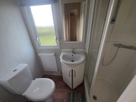 A bathroom with a shower and wash basin at Caravan 5 at Blackmoor Farm near Tenby