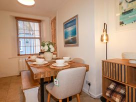 A dining room with a table set for meals at Chapel Cottage in Mevagissey
