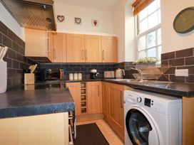A kitchen with cabinets and appliances at Chapel Cottage in Mevagissey