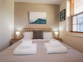 A bedroom with a bed and bedside lamps at Chapel Cottage in Mevagissey