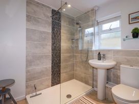 A bathroom with a shower, sink, and toilet at Chapel Cottage in Mevagissey