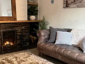 A living room with a sofa and a fireplace at Chapel Cottage in Mevagissey